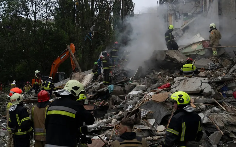 Rettungskräfte durchsuchen Trümmer eines Wohngebäudes.