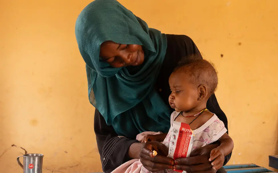 Eine Mutter schaut liebevoll auf ihr Kleinkind