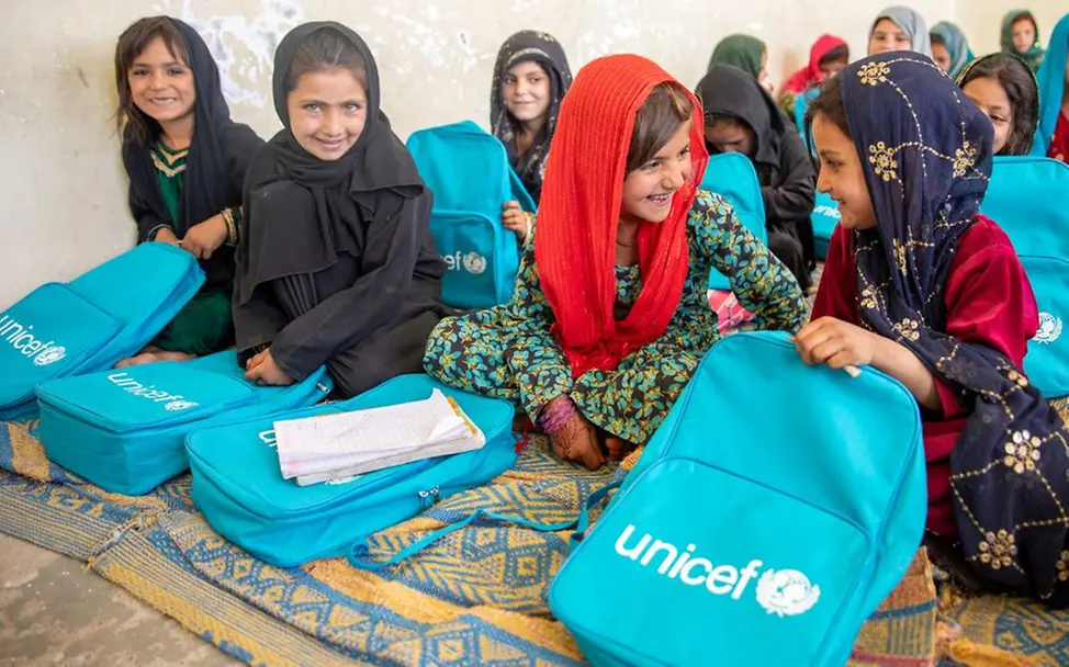 Mädchen einer Grundschulklasse erhalten Lernmaterialien und Rucksäcke. | © UNICEF/Khan Afghanistan: Grundschulkinder freuen sich über ihre neuen Schulrucksäcke.