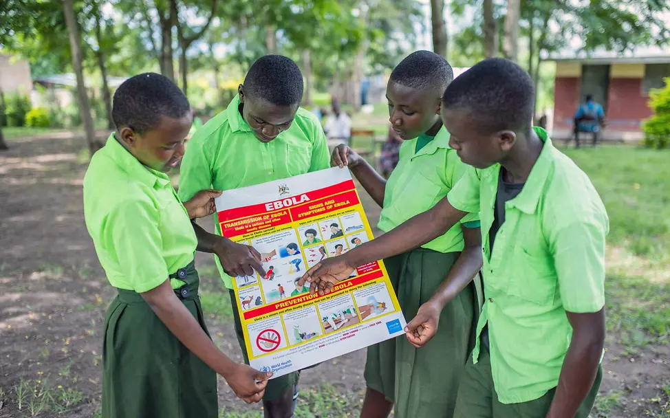 Schülerinnen und Schüler in Uganda sehen sich ein Infoplakat zu Ebola an. | © UNICEF/Bamulanzeki Ebola Aufklärung: Schülerinnen und Schüler in Uganda sehen sich gemeinsam ein Infoplakat zu Ebola an.