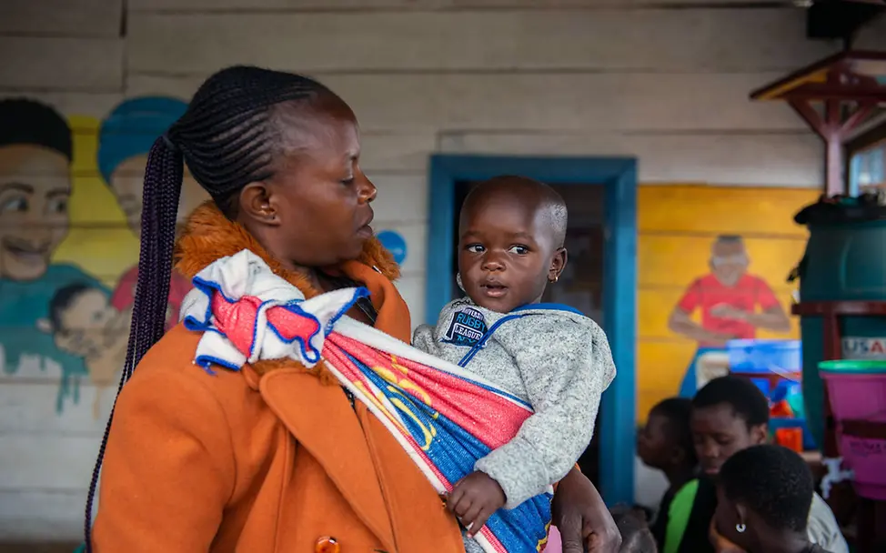 Eine Frau hält ihr Baby auf dem Arm. | © UNICEF/Bashizi Ebola: Eine Ebolaüberlebende mit ihrem Baby, das sie adoptiert hat, nachdem dessen Mutter an Ebola gestorben war.