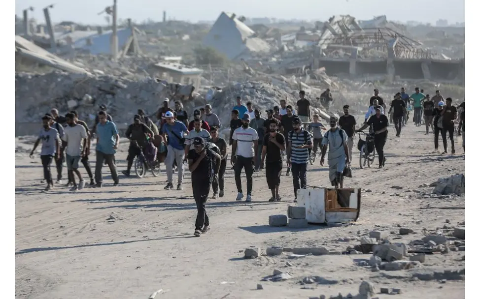 Familien in Gaza haben durch den Krieg alles verloren. | © UNICEF/UNI876914/Nateel Menschen aus Gaza laufen durch zerstörtes Gebiet.