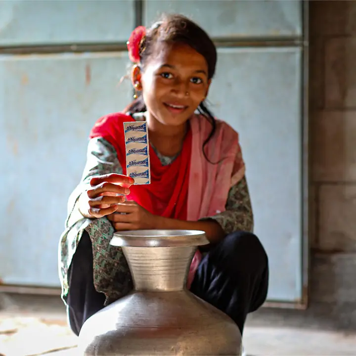 Tabletten zur Reinigung von Wasser können Wasser schnell und einfach sicher genießbar machen. Wasserreinigungstabletten vor ihrer Verwendung bei einem Krug voll Wasser.