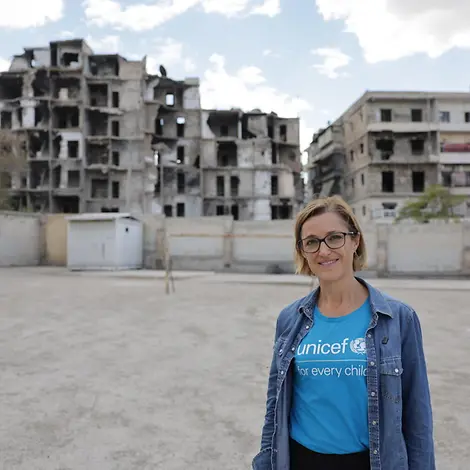 Ninja Charbonneau, Sprecherin von UNICEF Deutschland vor zerstörten Häusern in Syrien