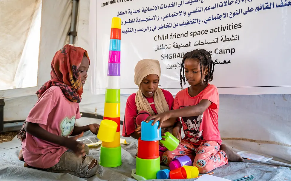 Drei Mädchen spielen mit Bauklötzen