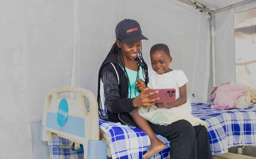 Eine von UNICEF unterstützte Psychologin kümmert sich um ein Kind in einer Krippe. | © UNICEF/Badimu Ebola Kongo: Eine von UNICEF unterstützte Psychologin kümmert sich um ein Kind, dessen Mutter wegen Ebola behandelt wird.