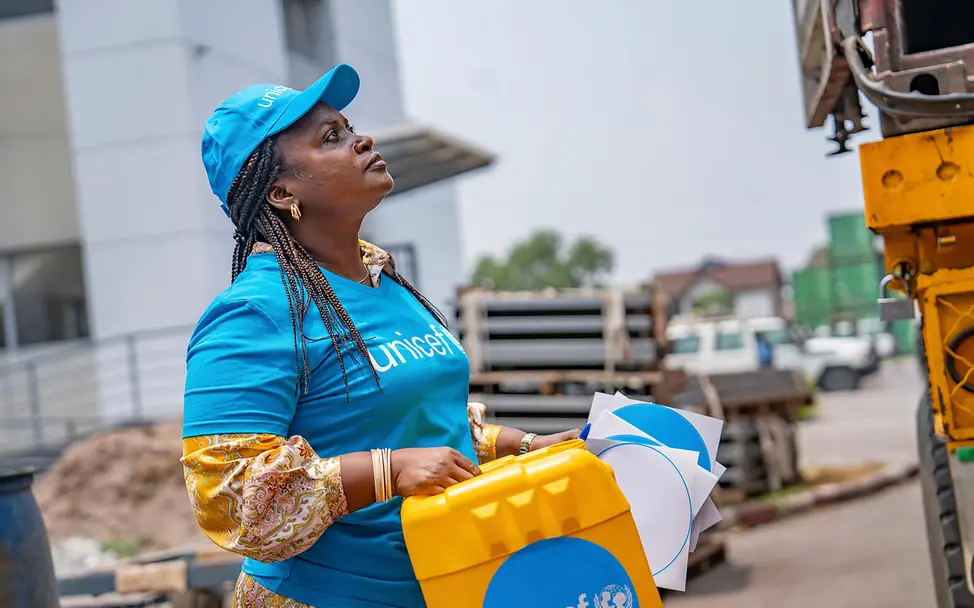 Eine UNICEF-Helferin in Kinshasa hilft beim Ausladen von UNICEF-Hilfsgütern. | © UNICEF/UNI860564/ Ebola Kongo: Beim Ebolaausbruch 2025 unterstützte UNICEF Kinder und Familien mit Hilfsgütern.