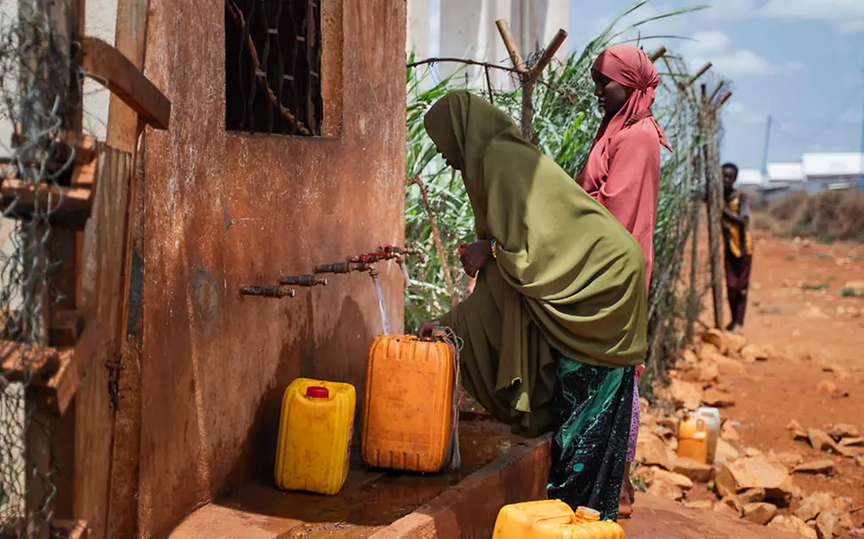 Somalia Hungerkrise: Zwei Frauen füllen ihre Wasserkanister an einer Wasserstelle.