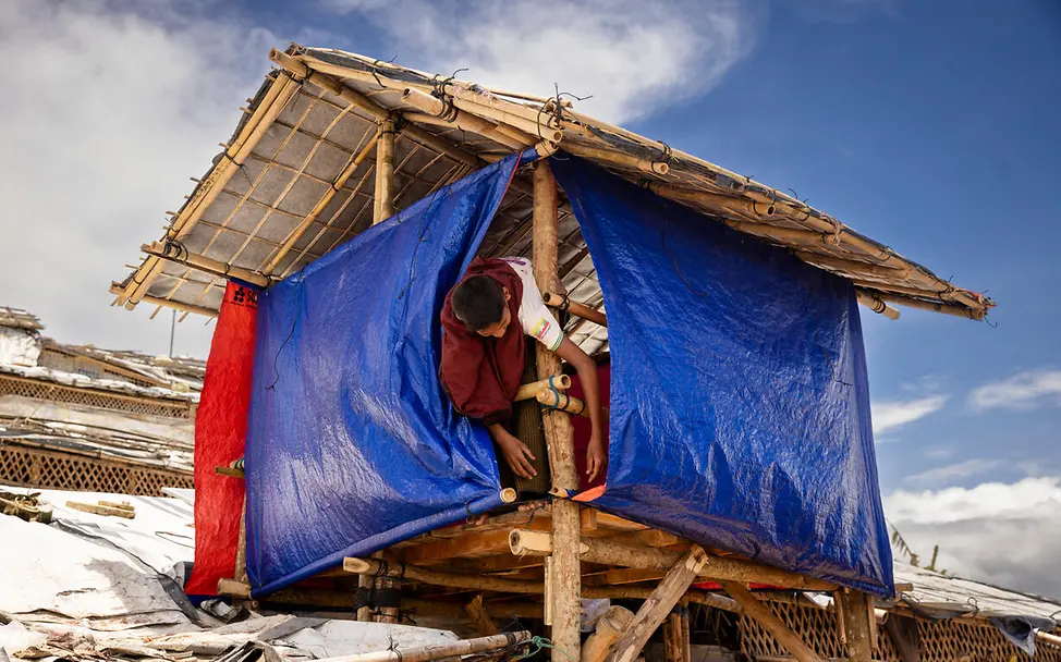 Rohingya Flüchtlingslager: Ein Junge befestigt eine Plane an seiner Hütte.