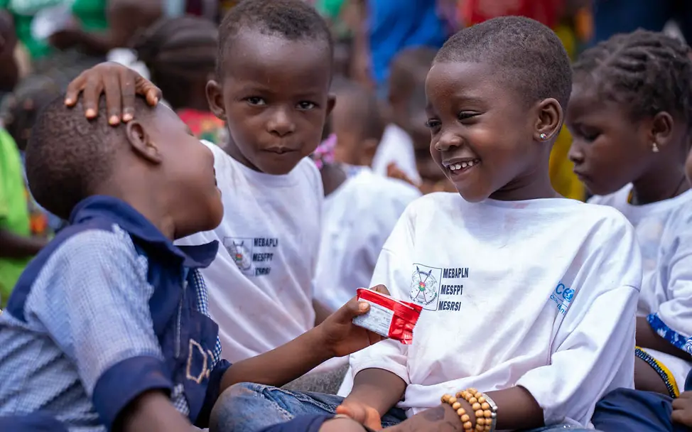 Kinderrechte für Kinder: Alle Kinder sollen gesund und in Frieden aufwachsen können. Kinderrechte leicht erklärt: Drei kleine Jungen sitzen lachend zusammen.