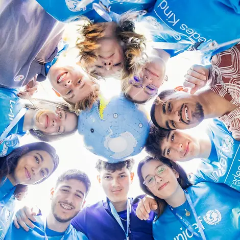 Teilnehmer und Globus in einem Teamkreis beim JugendFestival 2024.