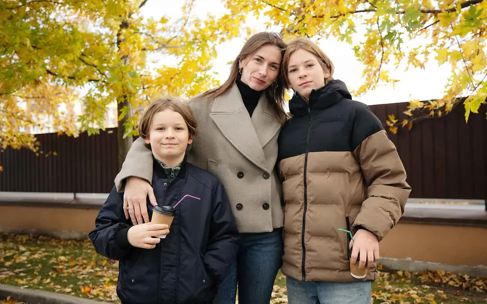 Menschenrechte einfach erklärt: In Ländern, in denen Krieg herrscht, werden die Menschenrechte häufig verletzt. Menschenrechte einfach erklärt: Eine Mutter steht mit ihren Kindern vor herbstlichen Bäumen.