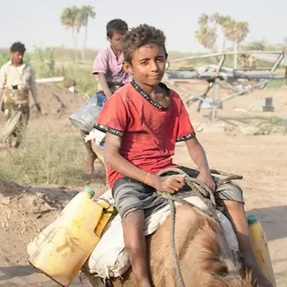 Mohammed (11) ist glücklich, nachdem er nahe von seinem Zuhause Wasser holen konnte. 