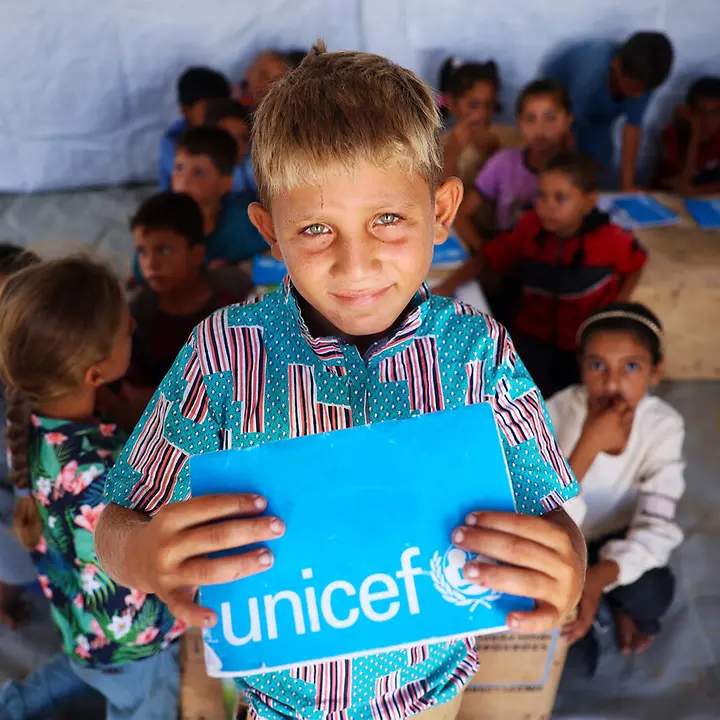 Gaza spenden: Ein Junge zeigt in einem Lernzentrum sein UNICEF-Schulheft. 