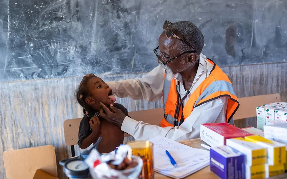 Ein Arzt untersucht ein Kind in der von UNICEF unterstützten mobilen Klinik.