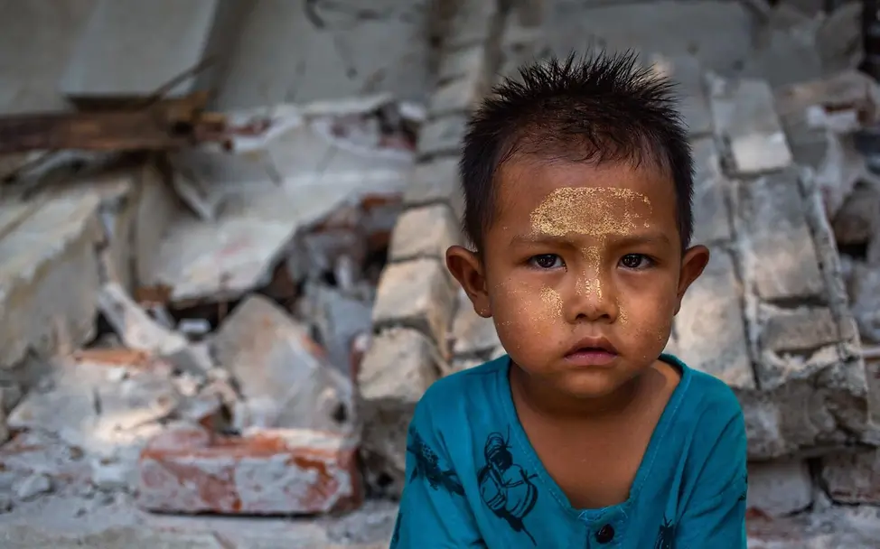 Ein Junge in den Trümmern eines Hauses