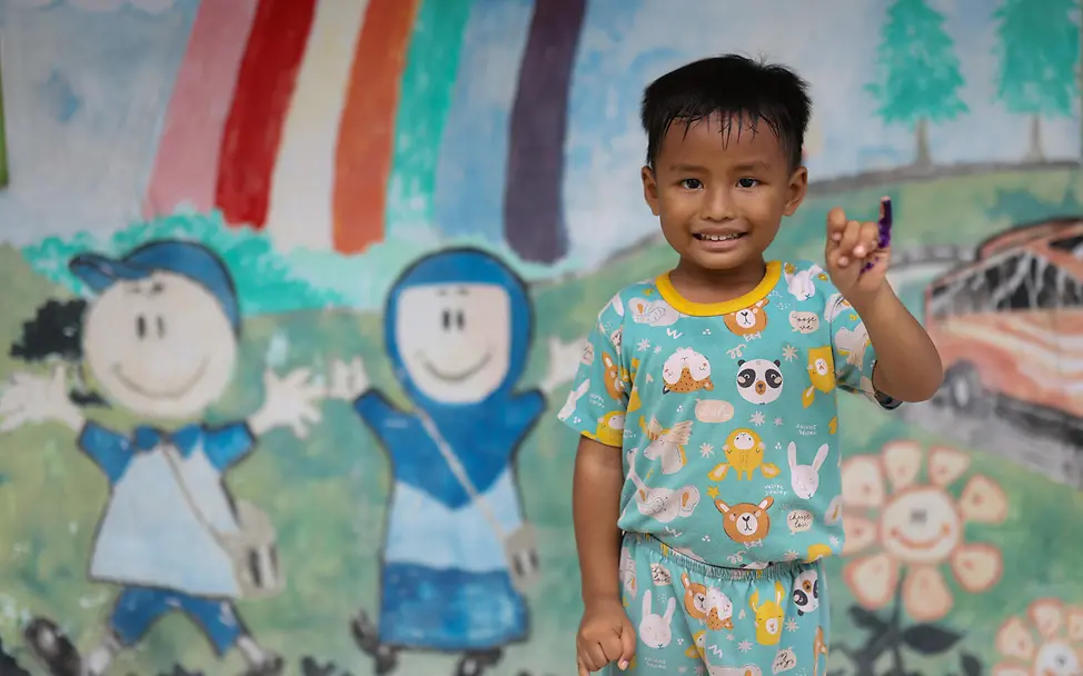Ein vierjähriger Junge lächelt in die Kamera, nachdem er im Dorf Banjardawa in Zentraljava eine Polio‑Impfung erhalten hat.