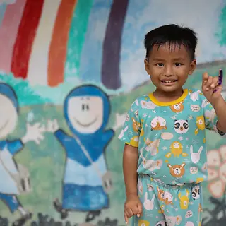 Ein vierjähriger Junge lächelt in die Kamera, nachdem er im Dorf Banjardawa in Zentraljava eine Polio‑Impfung erhalten hat.