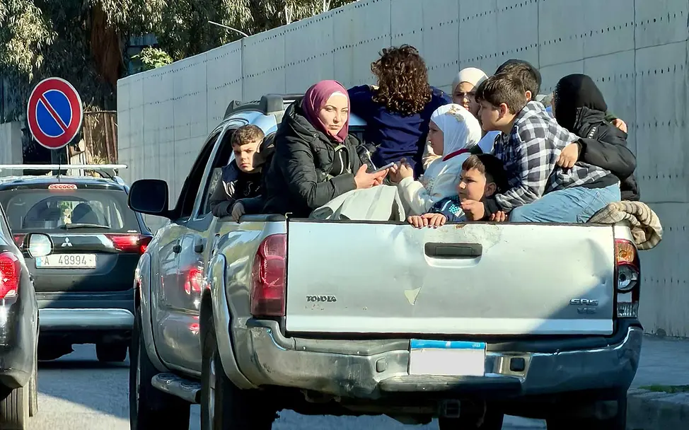 Libanon Gewalt: Menschen sitzen dicht gedrängt auf der Ladefläche eines Pickups, um den Kämpfen zu entkommen 