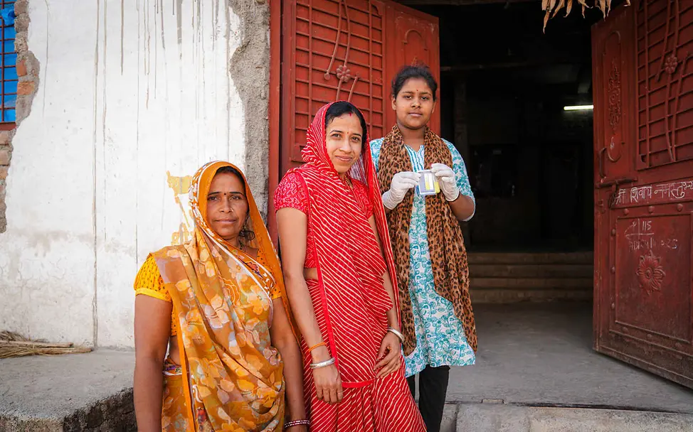 Wasserkrise: In vielen Ländern kann das Grundwasser und Leitungswasser die Menschen krank machen. | © UNICEF/Misra Wasserknappheit weltweit: Ein Mädchen und zwei Frauen zeigen einen Feldtest für Trinkwasser.