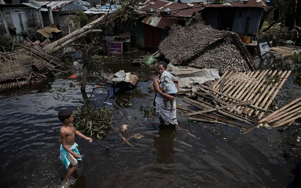Wasserkrise: Der Klimawandel bedroht das Leben und das Zuhause von Millionen von Menschen. | © UNICEF/Andriantsoarana Wasserknappheit weltweit: Eine Frau und ihr Baby stehen im Wasser vor ihrem zerstörten Haus.