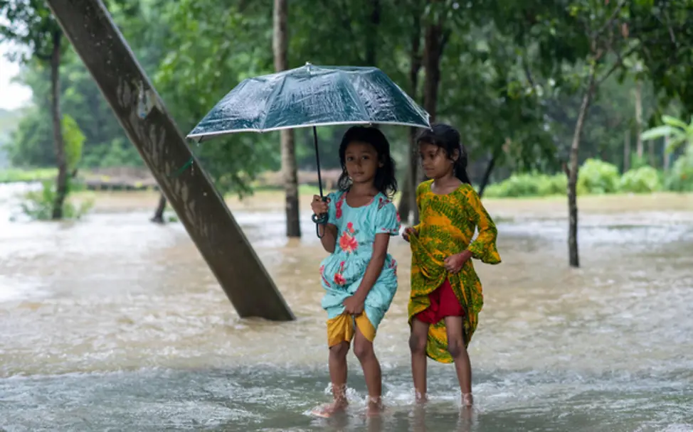 Kinder waten durch hüfthohes Wasser zur Evakuierung in Feni, Bangladesch