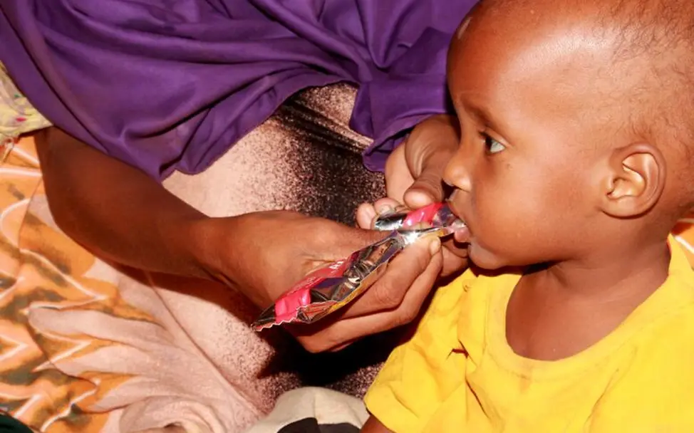 Hungerkrise in Kenia: Die nährstoffreiche Erdnusspaste hilft den hungernden Kindern, zu Kräften zu kommen. | © UNICEF Hunger in Kenia: Ein mangelernährtes Kleinkind wird mit Spezialnahrung gefüttert.