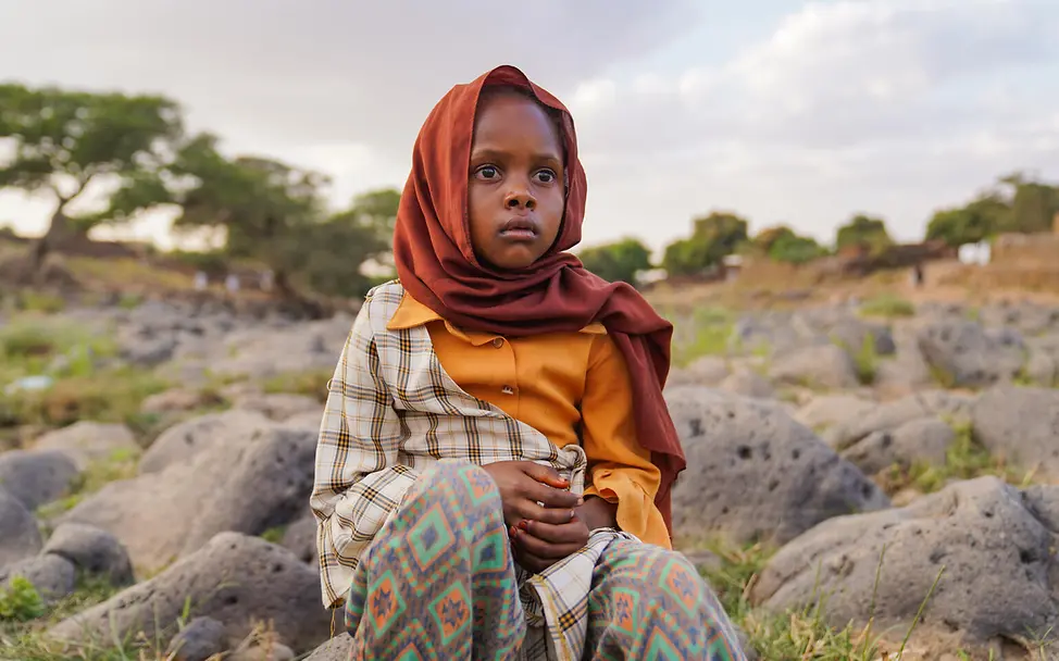 Mädchen sitzt auf Steinen