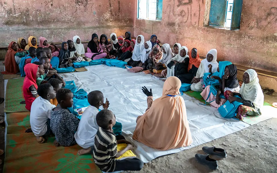 Kinder sitzen auf dem Boden und sprechen zusammen