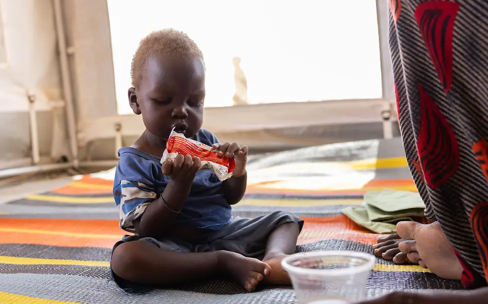 Mujahid erholt sich langsam von Mangelernährung. | © UNICEF/UNI951427/Dawod Sudan Hungersnot: Kleinkind isst Erdnusspaste