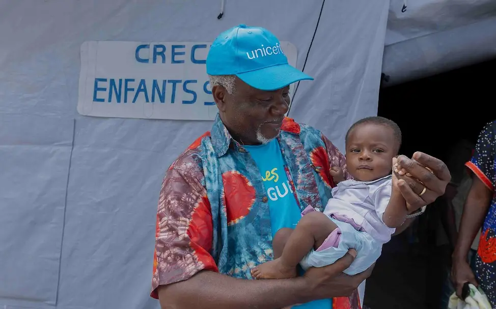 Ein UNICEF Mitarbeiter mit Baby