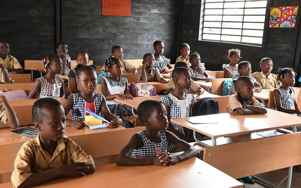 Das Recycling-Projekt von UNICEF löst das Müllproblem und verbessert die Bildungschancen in der Elfenbeinküste. | © UNICEF/Dejongh Elfenbeinküste Bildung: Schulkinder sitzen in einem Klassenraum aus recycelten Plastikziegeln.