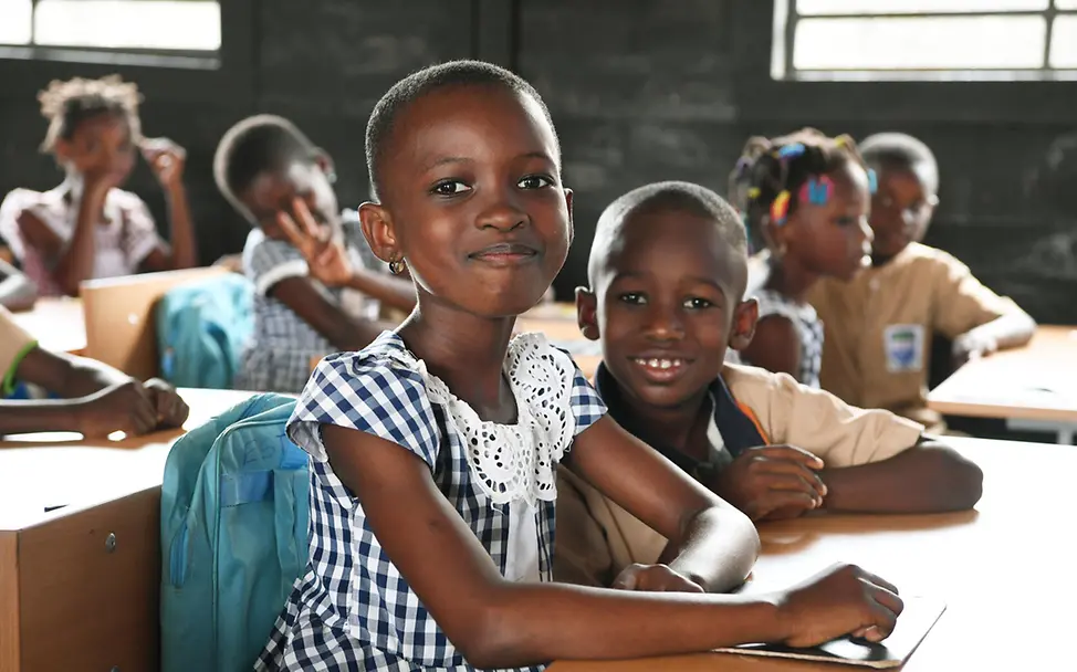 UNICEF unterstützt den Bau von Schulen in der Elfenbeinküste. | © UNICEF/Dejongh Bildung für die Elfenbeinküste: Schulkinder in einer Schule aus Recycling-Ziegeln lächeln in die Kamera.