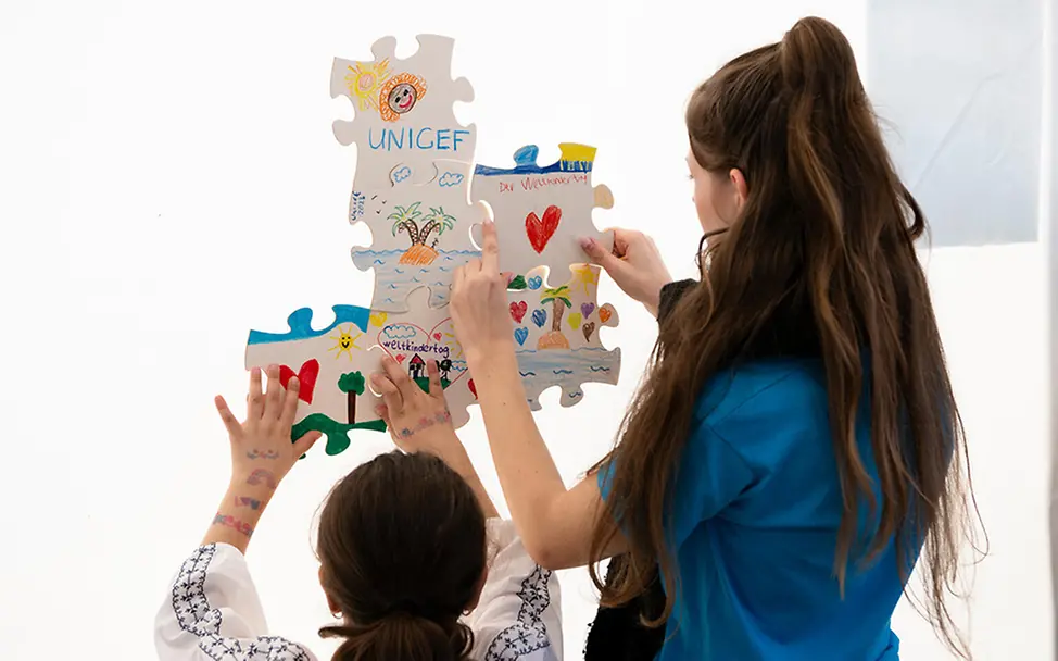 Ehrenamtlich aktiv für UNICEF: Engagierte bastelt zusammen mit einem Mädchen. | © UNICEF/Etges Ehrenamtliches Engagement für UNICEF: Engagierte bastelt zusammen mit einem Mädchen.