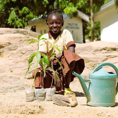 In Kamerun pflanzt ein Kind Setzlinge. | © UNICEF/Beguel Klimawandel für Kinder erklärt: Ein Kind pflanzt Setzlinge ein.