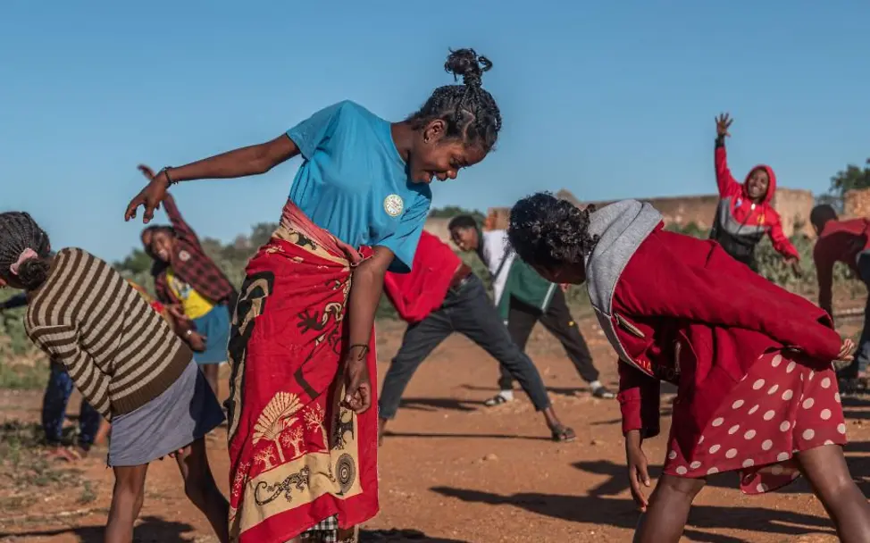 Jugendliche machen eine Gruppenaktivitaet im Freien | © UNICEF/UNI832818/Andrianantenaina Jugendliche nehmen an einer spielerischen Gruppenaktivität während einer Life-Skills-Session im Freien teil.