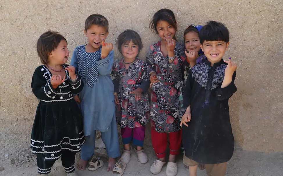 UNICEF versorgt Kinder weltweit mit Impfstoffen gegen vermeidbare Krankheiten wie Polio. | © UNICEF Impfen einfach erklärt: Kinder halten lachend ihre farbig markierten Finger in die Kamera.