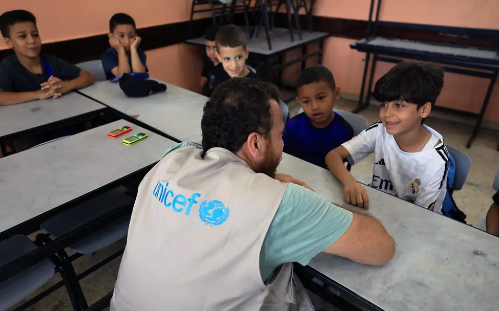 Westjordanland Aufwachsen spenden: Ein UNICEF-Helfer unterhält sich in einem Klassenzimmer mit palästinenischen Jungen.