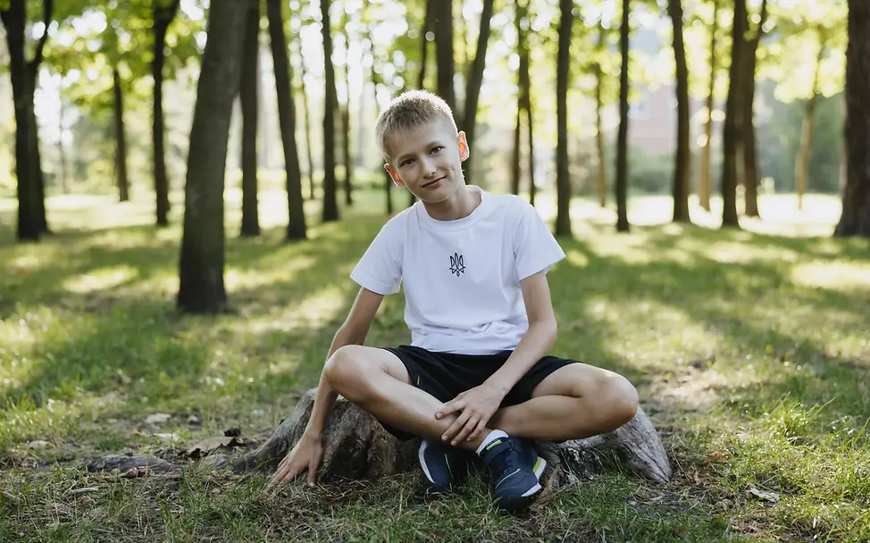 Hitze Kleinkind: Alex (8) sitzt im Schatten unter Bäumen in einem Park und ruht sich aus.