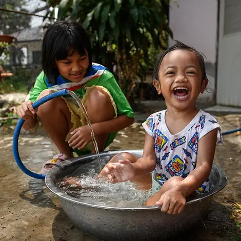 Hitze Kleinkind: Die Geschwister Khemajira Somnaijai (Nam) und Sirinda Somnaijai (Fon) spielen glücklich mit Wasser.
