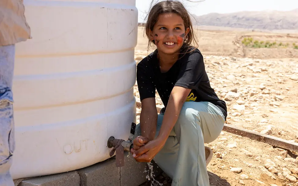 Aufwachsen im Westjordanland: Ein Mädchen in einer Beduinengemeinschaft nahe Ramallah zapft Wasser aus einem UNICEF-Tank. 