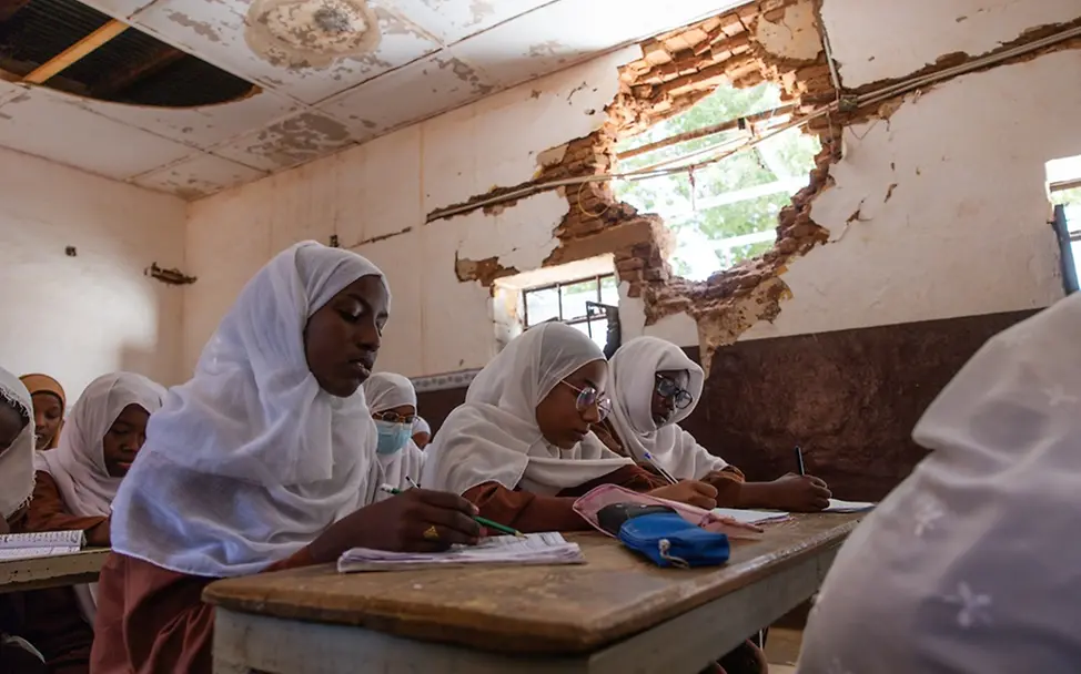 Schulen werden in Kriegen oft zu Zielen von Angriffen | UNICEF/Elfatih Schwere Kinderrechtsverletzungen: Im Sudan sitzen Mädchen in einer beschädigten Schulen