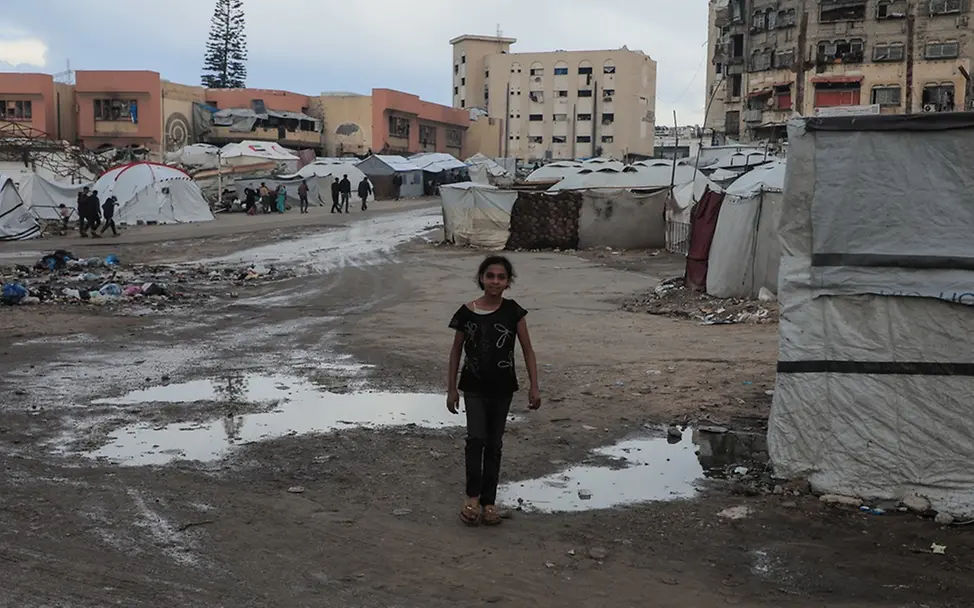 Tausende Kinder in Gaza leben unter prekären Bedingungen | UNICEF/Nateel Schwere Kinderrechtsverletzungen: In Gaza läuft ein Mädchen durch ein überflutetes Flüchtlingscamp