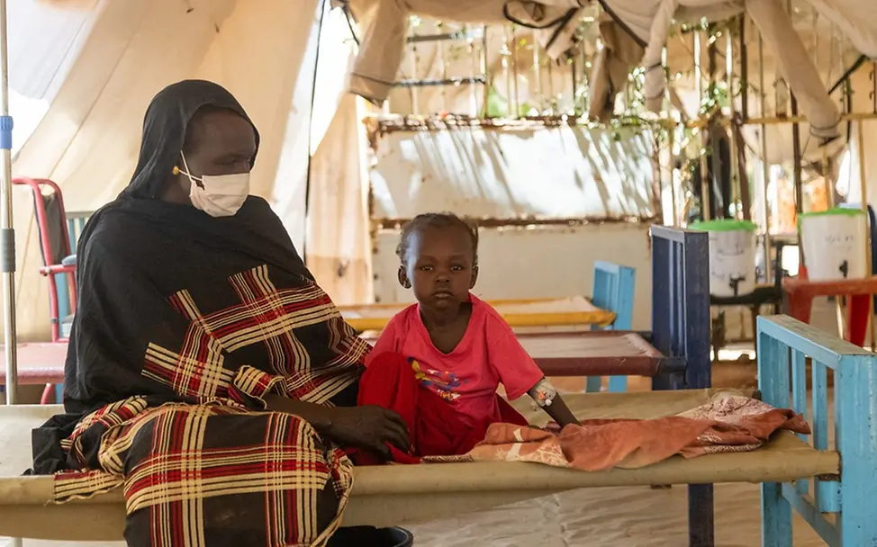 Cholera ist besonders für Kinder gefährlich | UNICEF/Elfatih Sudan Krieg: Eine Mutter sitzt mit ihrer Tochter auf einem Krankenbett