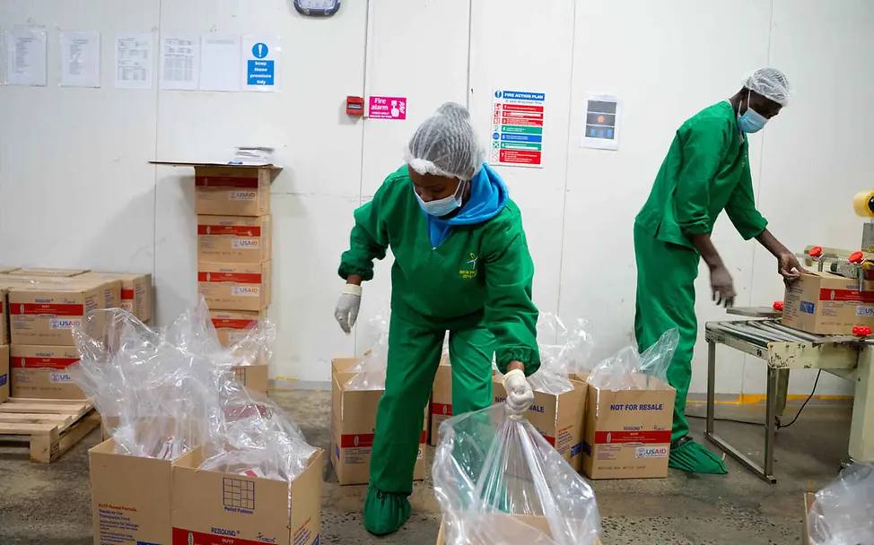 Die Fabrik in Kenia beschäftigt zu 99 Prozent einheimische Mitarbeiter*innen. | © UNICEF/Ekwam Erdnusspaste Herstellung: Zwei Mitarbeiter*innen in der RUTF-Fabrik verpacken Erdnusspaste in Kartons.