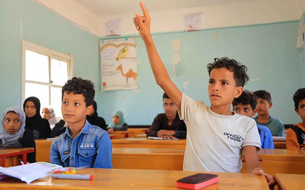 UNICEF setzt sich dafür ein, dass Kinder zur Schule gehen können, anstatt zu arbeiten. | © UNICEF/Mohammed Bildung einfach erklärt: Ein Schüler im Klassenzimmer meldet sich.