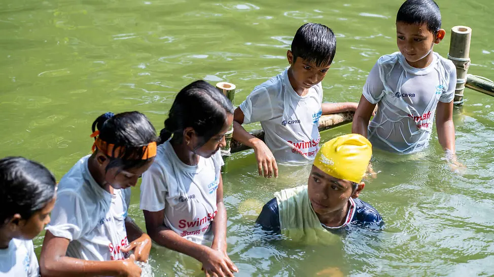 Hochwasser Folgen: Ein Mädchen macht im Fluss Schwimmübungen mit Kindern.
