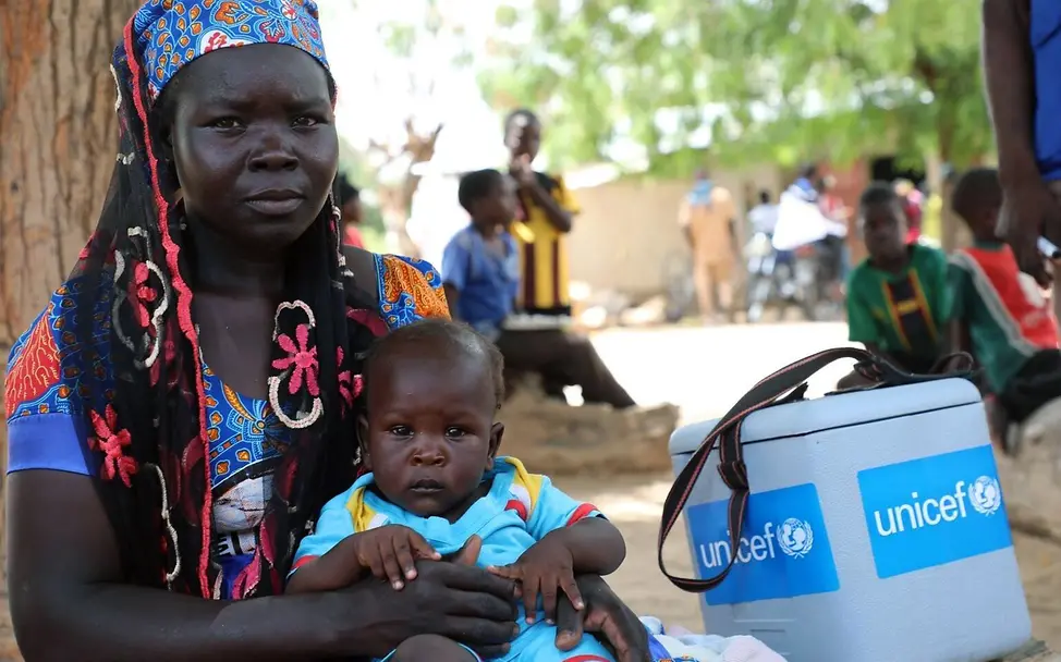 Eine Mutter wartet mit ihrem Baby in Kamerun auf die Polioimpfung. | © UNICEF/Beguel Polio Impfung: Eine Mutter wartet mit ihrem Baby in Kamerun auf die Impfung gegen Poliomyelitis.