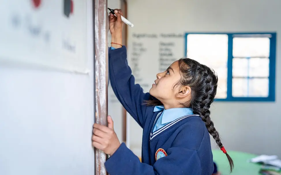 Die 9-jährige Sarjana schreibt auf eine Tafel. | © UNICEF/Upadhayay Die 9-jährige Sarjana schreibt auf eine Tafel.