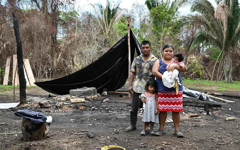 Ausgedehnte Waldbrände nehmen vielen Familien ihr gesamtes Hab und Gut. | © UNICEF/Dejongh Waldbrände Folgen: Eine Familie mit zwei kleinen Kindern steht vor einem provisorischen Zelt.